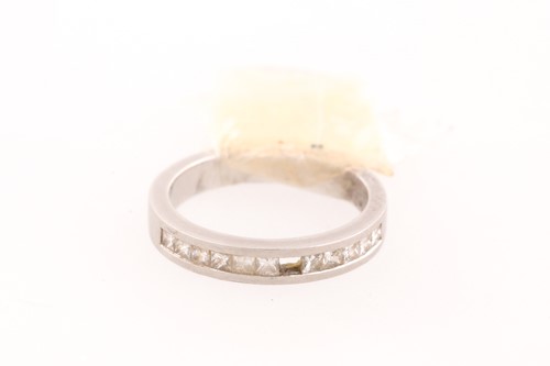 Lot 106 - A diamond half hoop eternity ring; channel set...