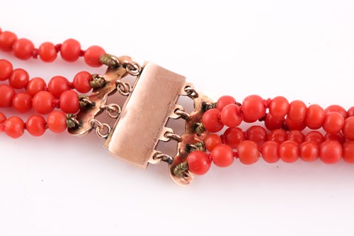 Lot 299 - A yellow metal and coral beaded necklace,...