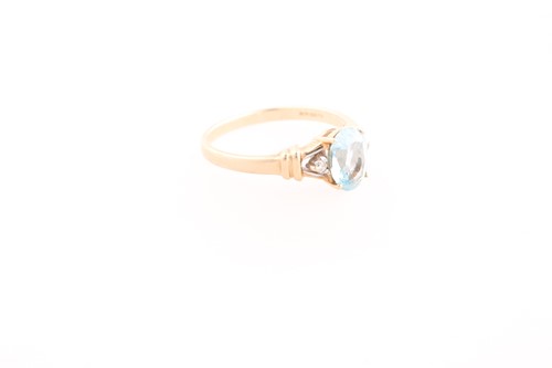 Lot 242 - A 9ct yellow gold, diamond, and blue topaz...