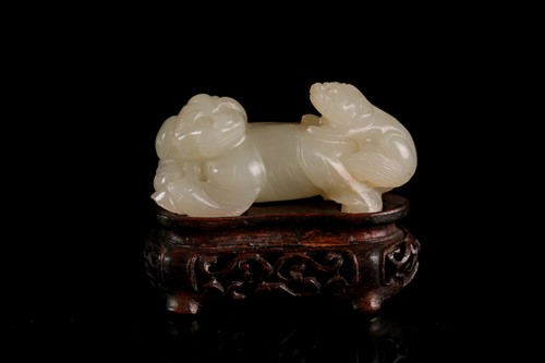 Lot 108 - A Chinese carved pale green jade figure of a...