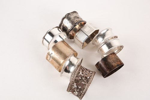 Lot 414 - A collection of nine silver napkin rings of...