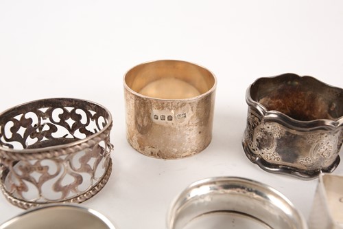 Lot 414 - A collection of nine silver napkin rings of...