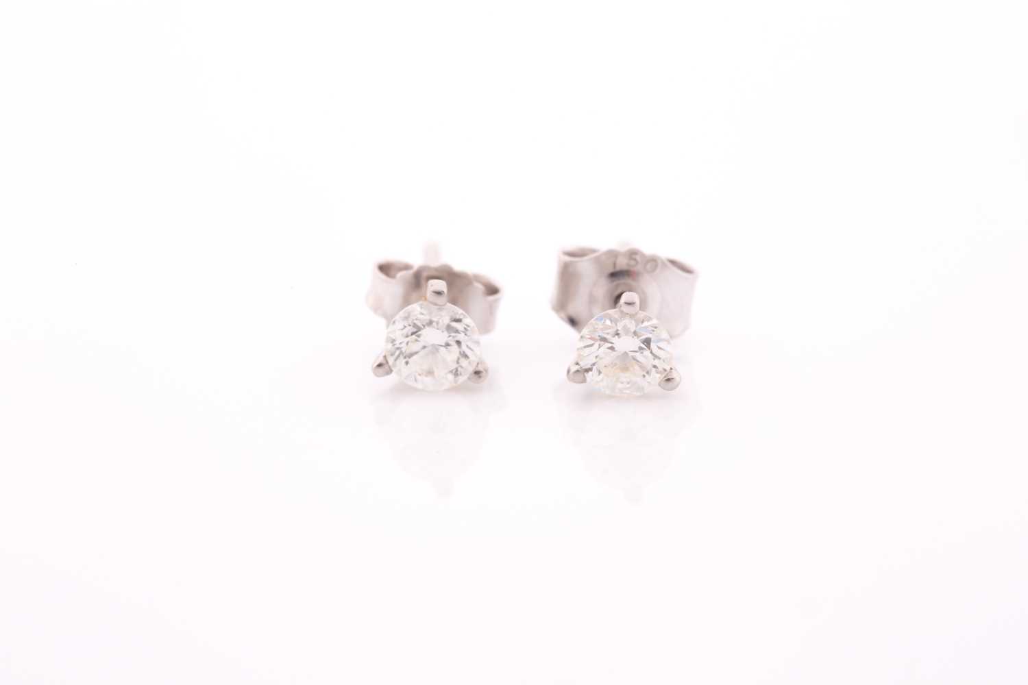 Lot 162 - A pair of solitaire diamond stud earrings, set...