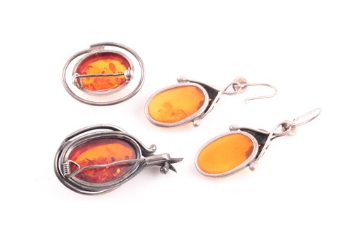 Lot 21 - Two silver and pressed amber brooches,...