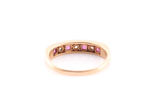 Lot 201 - A ruby and diamond half hoop ring, channel set...