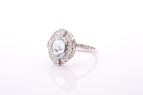 Lot 90 - An aquamarine and diamond oval cluster ring in...