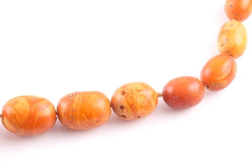 Lot 71 - A butterscotch amber beaded necklace, the...