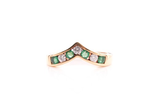 Lot 75 - An emerald and diamond seven stone half hoop...
