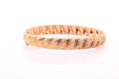 Lot 285 - A 9ct yellow gold bangle, of twisted design...