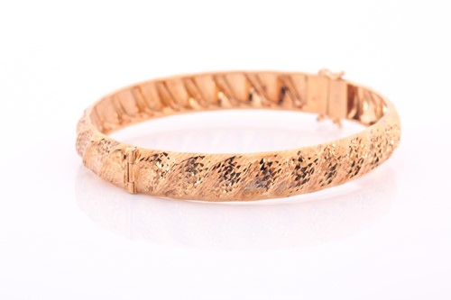 Lot 285 - A 9ct yellow gold bangle, of twisted design...
