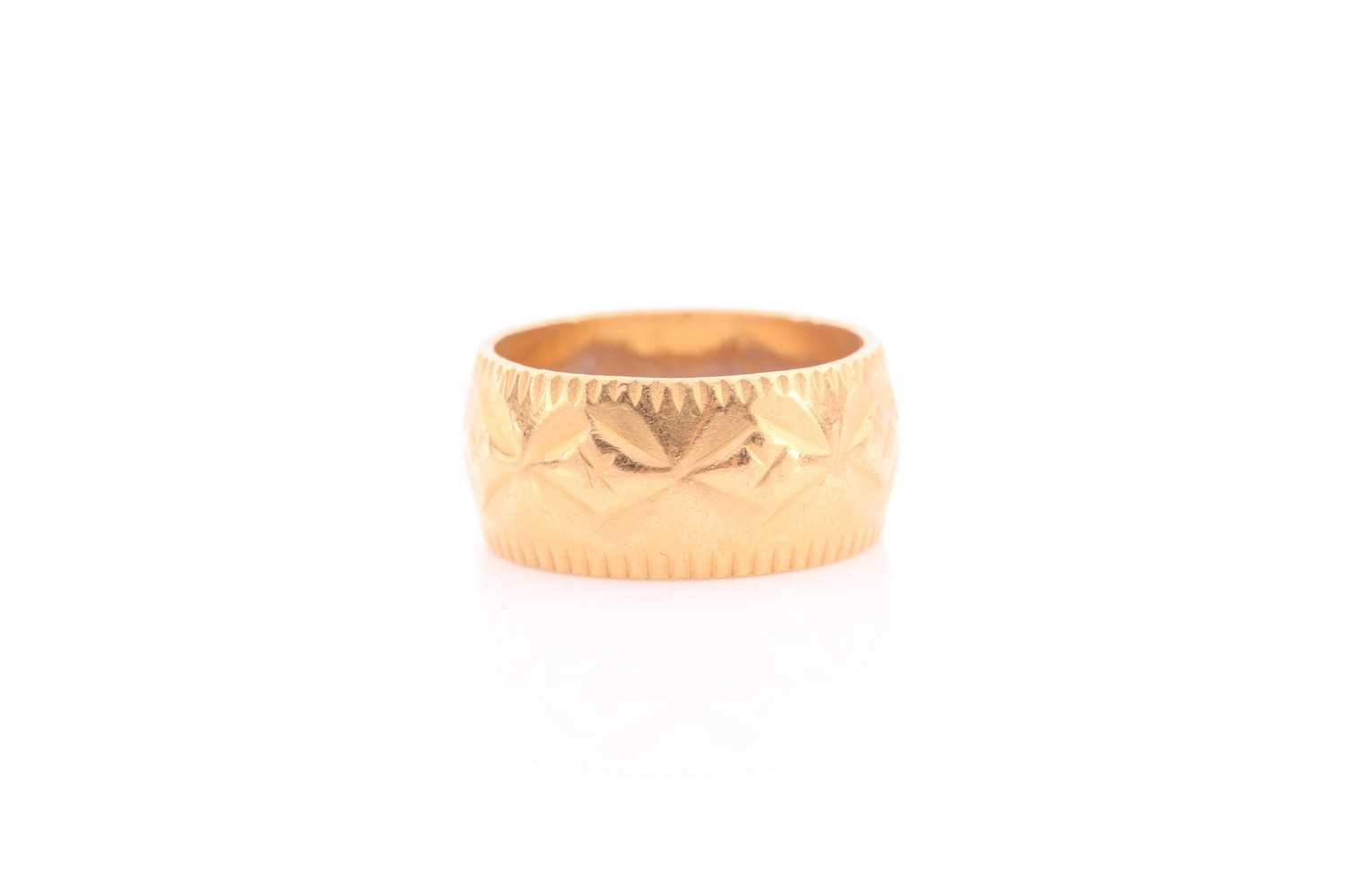 Lot 144 - A yellow metal band ring, with repousse...