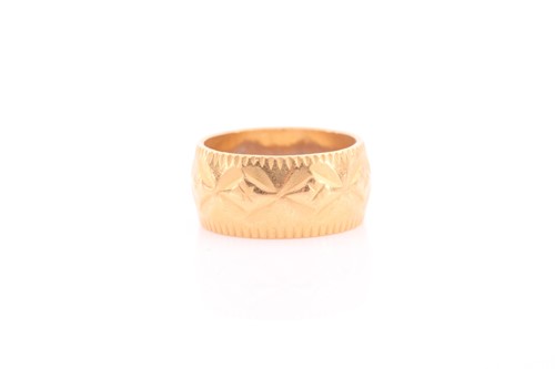 Lot 144 - A yellow metal band ring, with repousse...