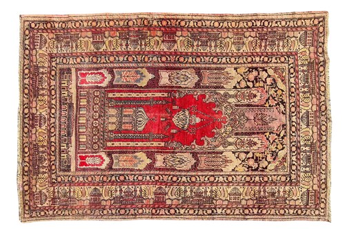 Lot 108 - An old red ground Turkish prayer rug with...