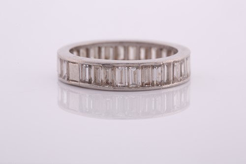 Lot 253 - A white metal and diamond eternity ring, set...