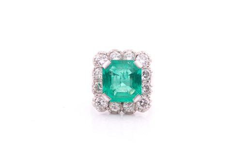 Lot 119 - An emerald and diamond cluster ring; the...