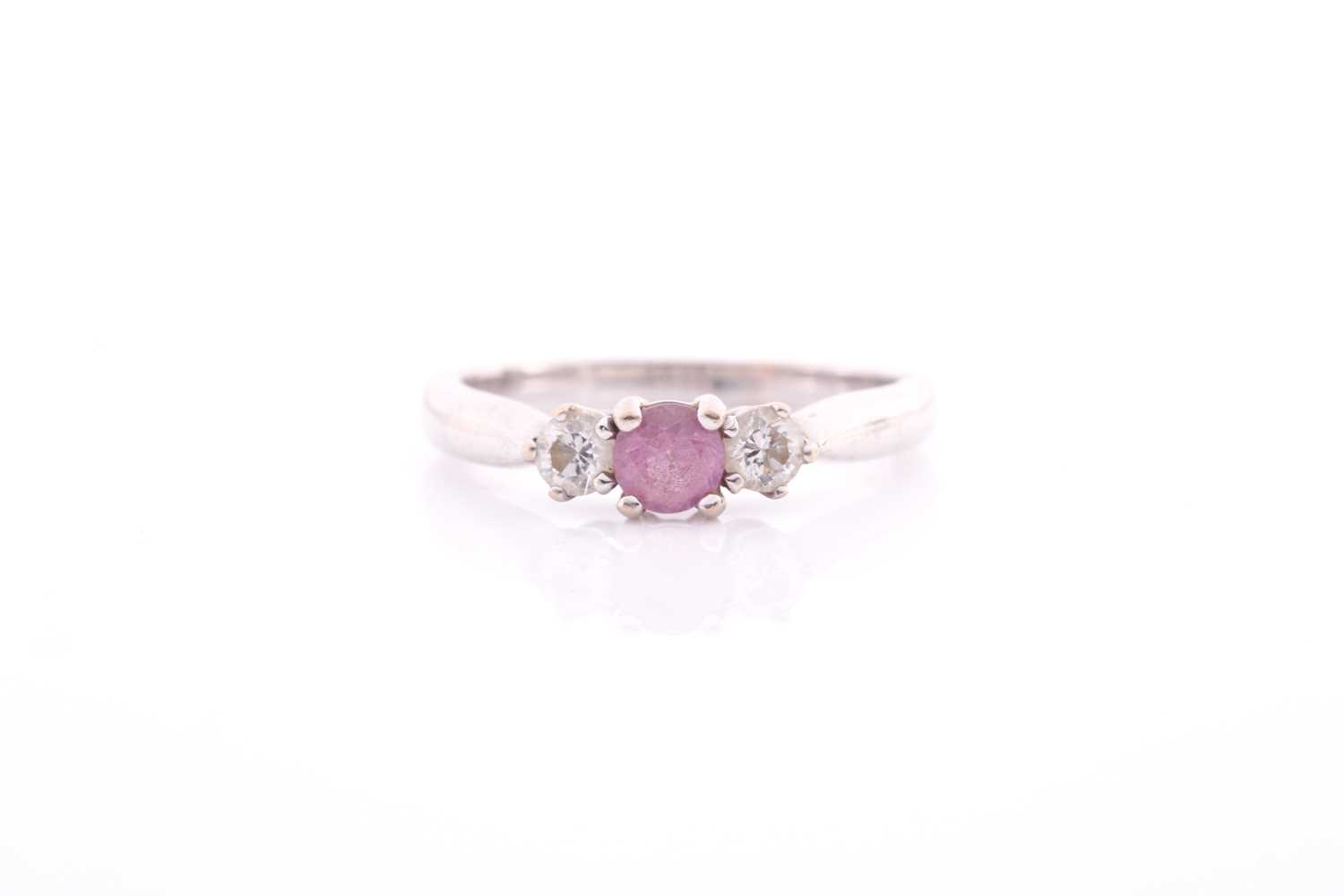 Lot 83 - A pink sapphire and diamond three stone half...