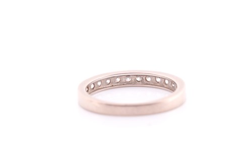 Lot 136 - A twelve stone half hoop diamond eternity ring;...
