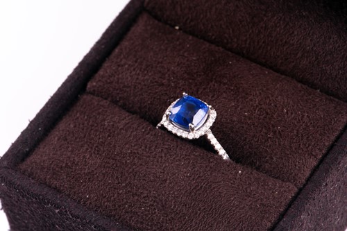 Lot 62 - A sapphire and diamond cluster ring; the...
