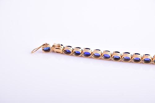 Lot 120 - A yellow metal and sapphire bracelet, set with...