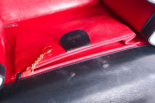 Lot 286 - A Gucci black leather handbag, of plain...
