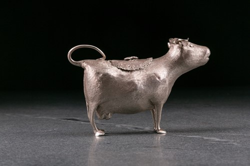 Lot 355 - A George III silver cow creamer. London 1764...