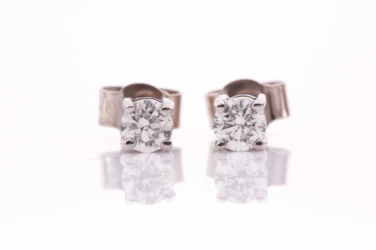Lot 97 - A pair of 18ct white gold and solitaire...