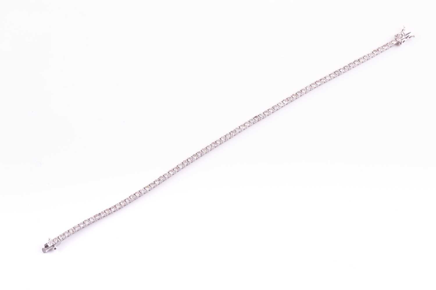Lot 120 - An 18ct white gold and diamond line bracelet,...
