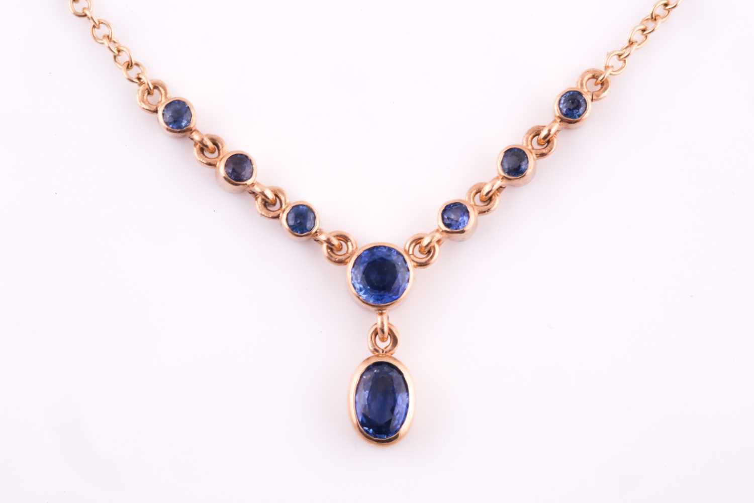 Lot 36 - A 9ct yellow gold and blue sapphire drop...
