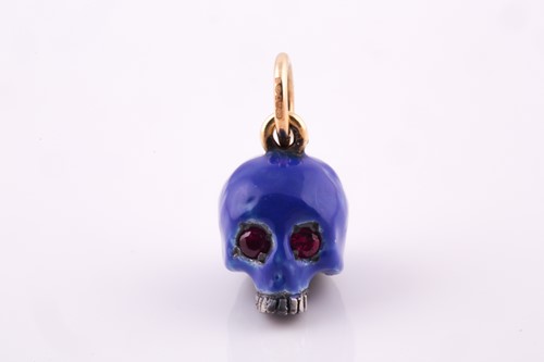 Lot 112 - An unusual enamel and ruby skull pendant, the...