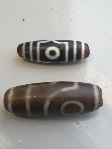 Lot 94 - A collection of five Tibetan carved agate Dzi...