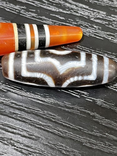 Lot 94 - A collection of five Tibetan carved agate Dzi...
