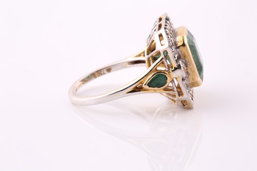 Lot 20 - An emerald and diamond cluster ring. The...
