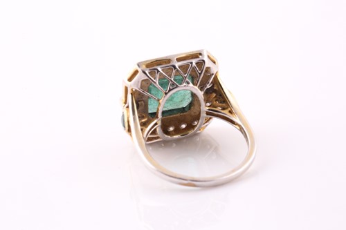Lot 20 - An emerald and diamond cluster ring. The...