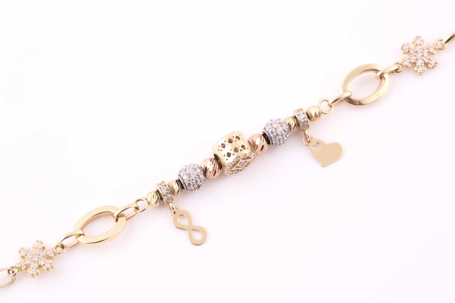 Lot 7 - A charm bracelet; the oval link chain strung...