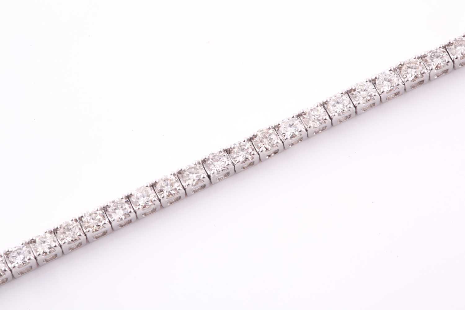 Lot 303 - An 18ct white gold and diamond line bracelet,...