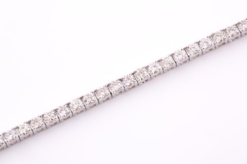 Lot 303 - An 18ct white gold and diamond line bracelet,...