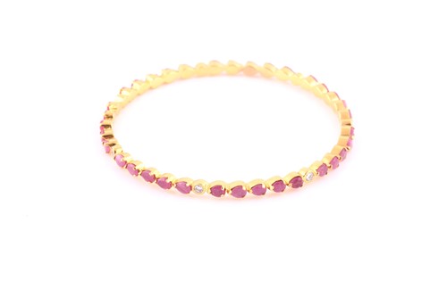 Lot 374 - A ruby and diamond bangle; composed of bands...