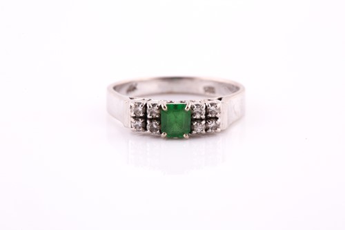Lot 451 - An emerald and diamond seven stone half hoop...
