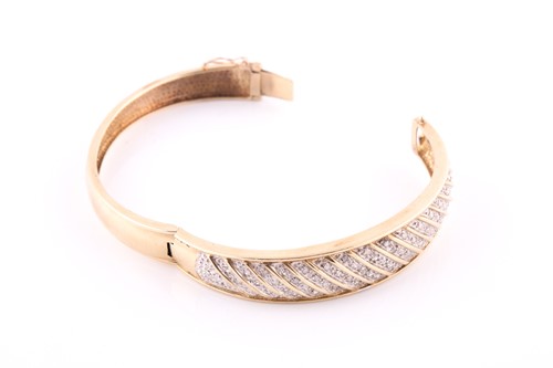 Lot 328 - A diamond bangle; the hinged, tapering,...