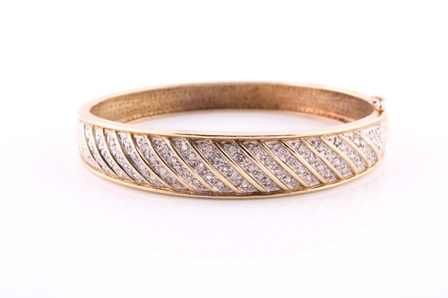 Lot 328 - A diamond bangle; the hinged, tapering,...