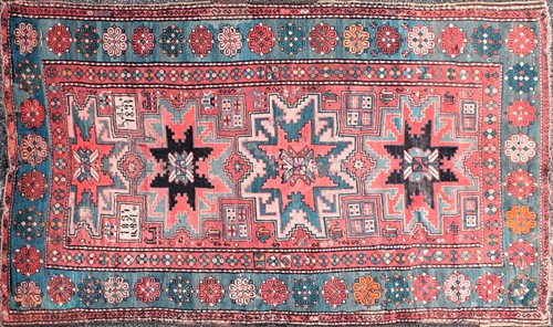 Lot 192 - An old red ground Kazak rug with three-star...
