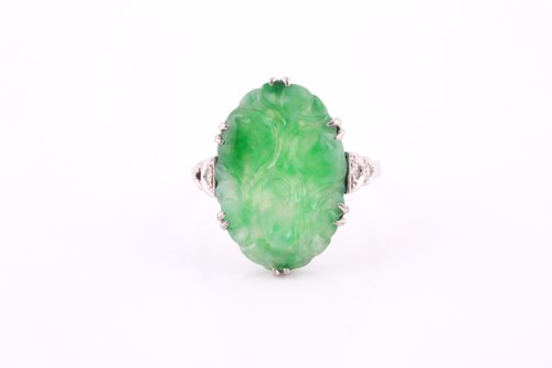 Lot 540 - An Art Deco carved jade and diamond ring; the...