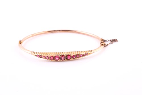 Lot 539 - A garnet-set hinged bangle Set to the front...