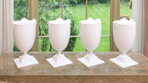 Lot 105 - A set of four white painted composition...