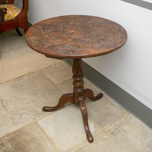 Lot 123 - A George III carved oak tripod wine table with...