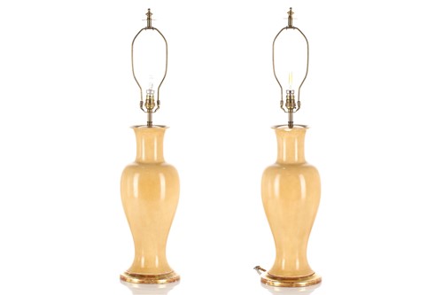 Lot 322 - A pair of cream baluster shaped vase lamps...