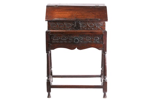 Lot 302 - An early 18th century carved oak slope fronted...