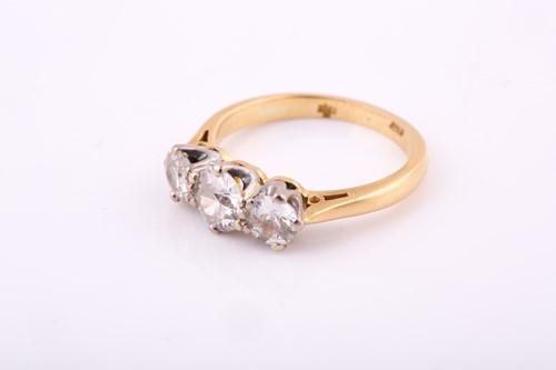 Lot 55 - An 18ct yellow gold three stone diamond ring,...