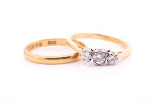 Lot 27 - A three-stone diamond ring and a wedding band....