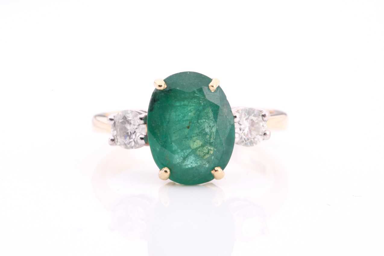 Lot 212 - A large emerald and diamond three stone ring...